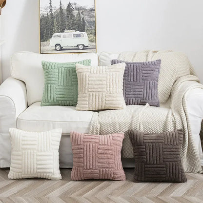 Decorative pillows on a sofa with a mountain landscape painting in the background