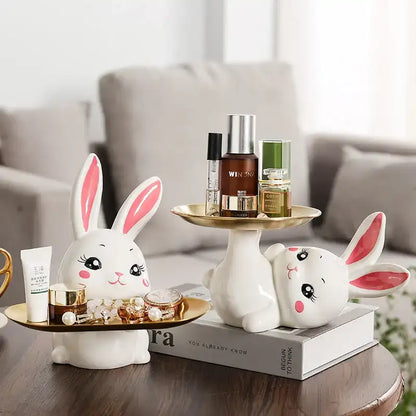 Decorative rabbit figurines with a small table and books on a blurred background
