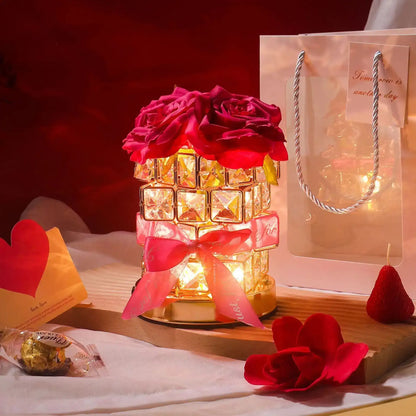 Decorative lamp with roses and a gift bag on a table