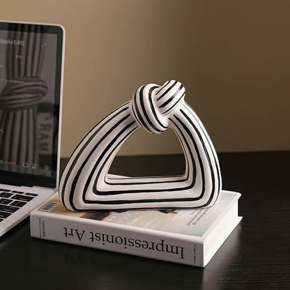 Decorative sculpture on a stack of books with a laptop in the background