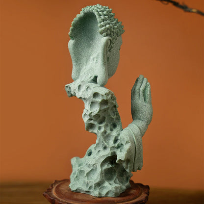 Decorative sculpture of a head with a hand on a wooden base against an orange background