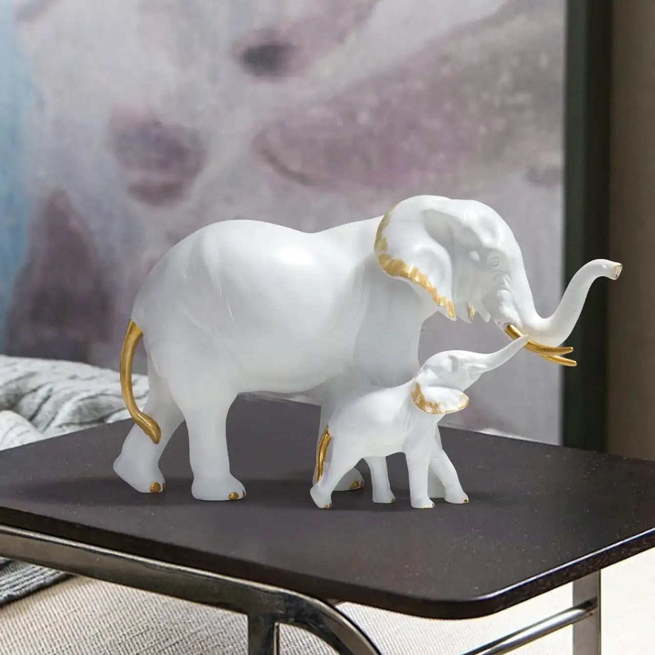Decorative white elephant figurine with gold accents on a dark surface