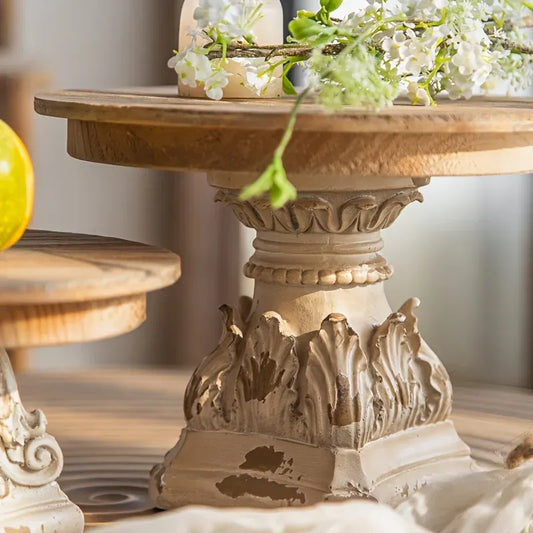 Decorative wooden table with intricate carvings and floral arrangement on a blurred background