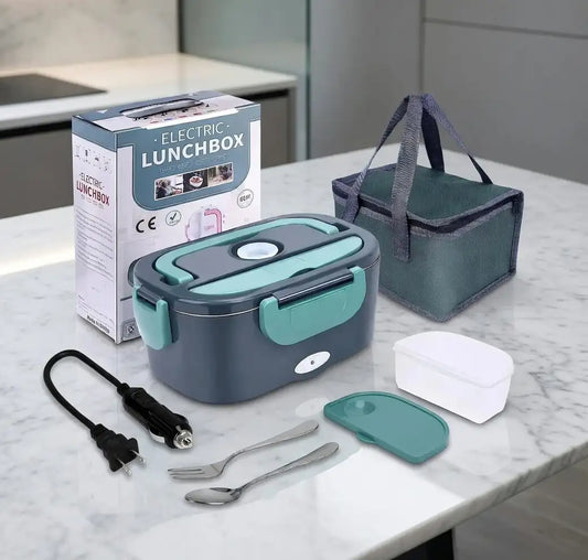 Electric lunchbox set with packaging, power cord, and utensils on a marble surface.