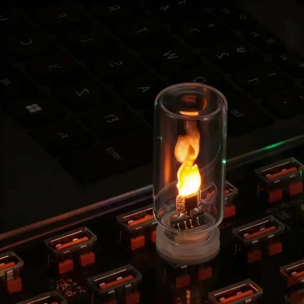 Small glowing light bulb in a transparent container on a keyboard