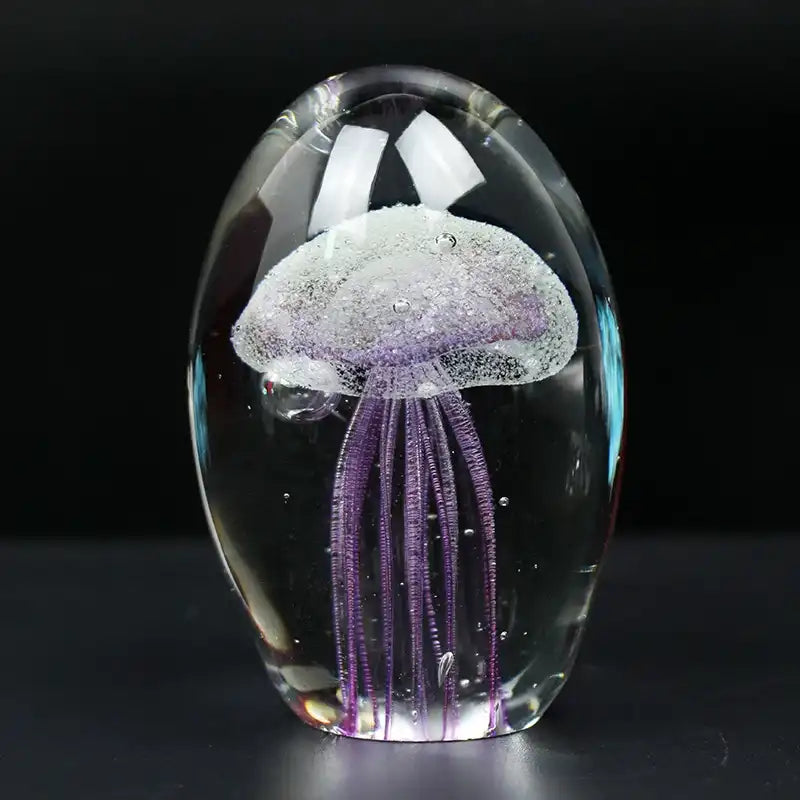 Glass paperweight with a jellyfish design on a black background