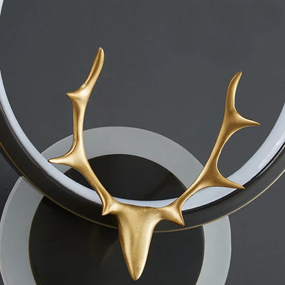 Gold deer antlers on a black and white circular background