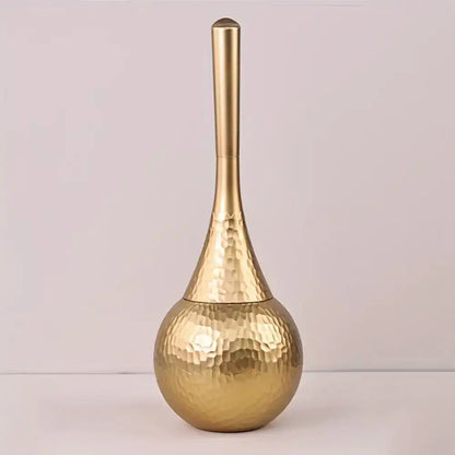 Gold toilet brush holder with a textured design on a light gray background