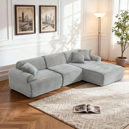 Gray sectional sofa in a living room with a rug and lamp.