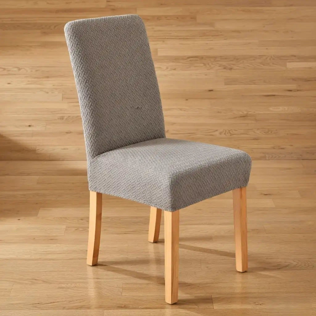 Gray upholstered chair with wooden legs on a wooden floor