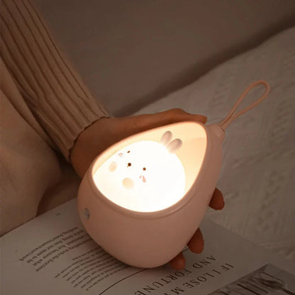 Cute night light shaped like a cat held over an open book