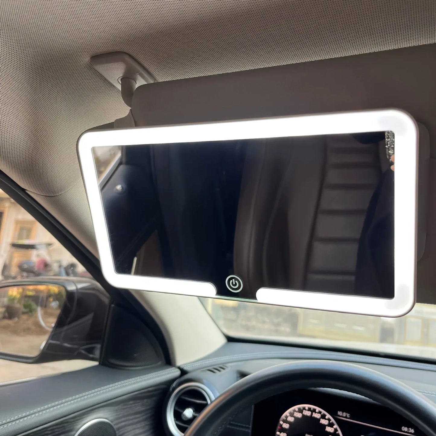 A car-mounted mirror with LED lights attached to a car's interior.