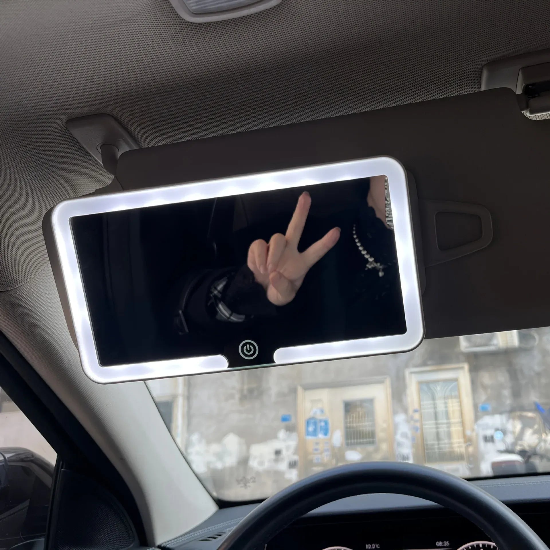Car interior with a mounted tablet displaying a hand gesture.