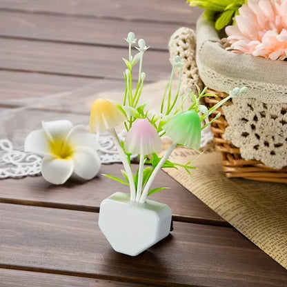 Small artificial plant in a white pot on a wooden surface with a basket and flowers in the background.