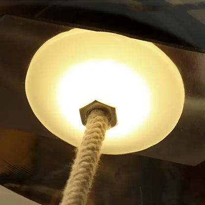 Light bulb with a white cord against a dark background