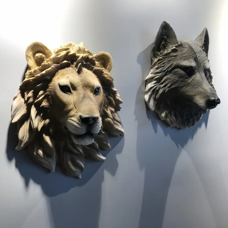 Lion and wolf head sculptures on a white wall