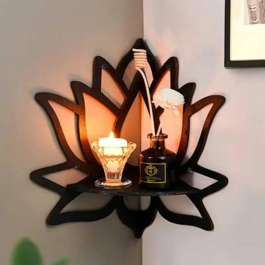 Decorative wall shelf shaped like a lotus with a candle and bottle on a light-colored wall.