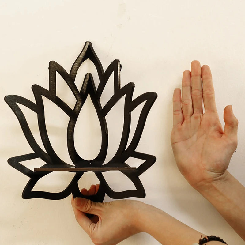 Black lotus-shaped trivet held by a hand against a white background