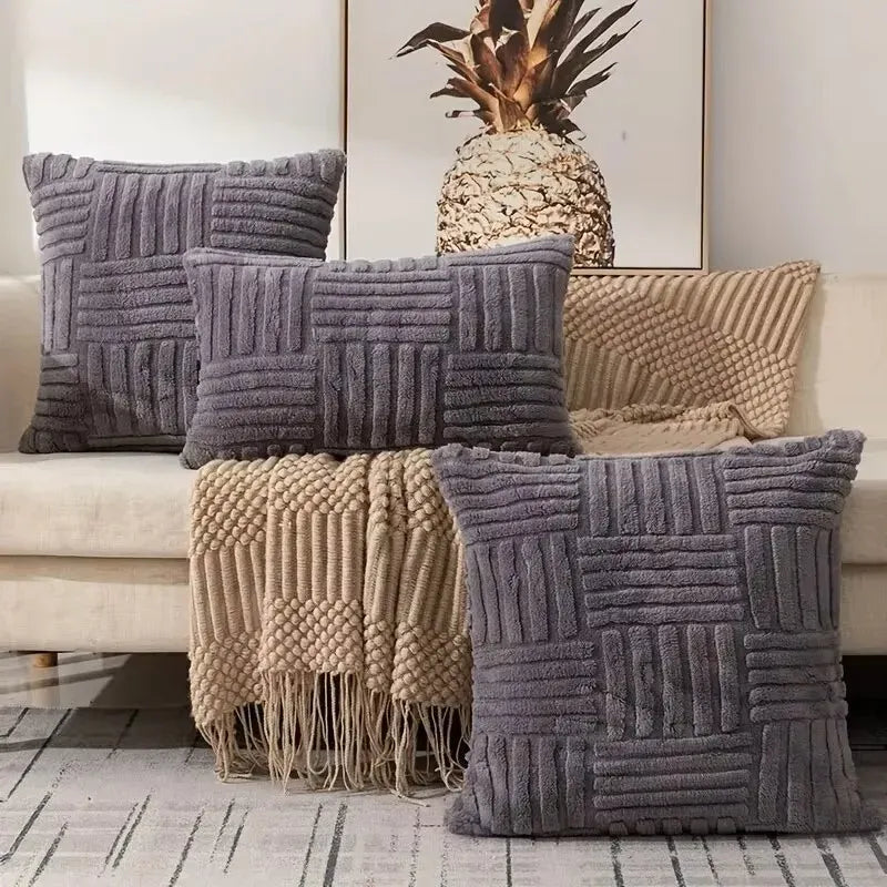 Textured throw pillows on a sofa with a decorative pineapple and framed picture in the background.