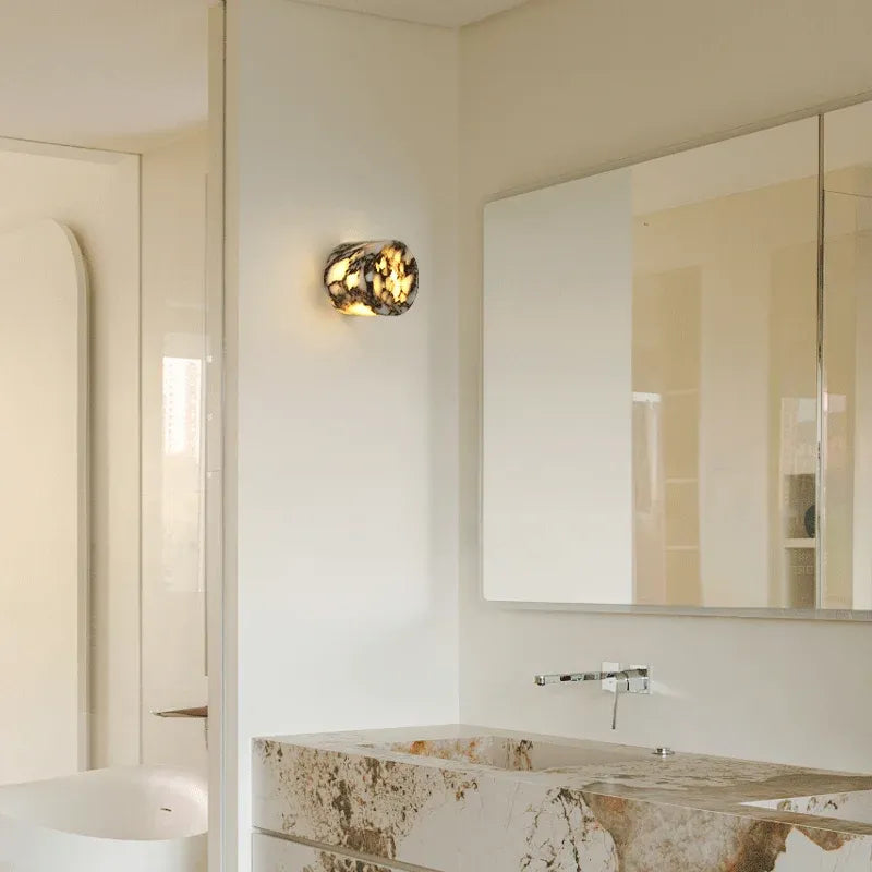Bathroom interior with a mirror, Marbled stone with brown and white pattern light fixture, and a bathtub.