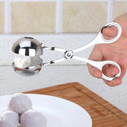 Metallic ice cream scoop held by a hand with a kitchen background