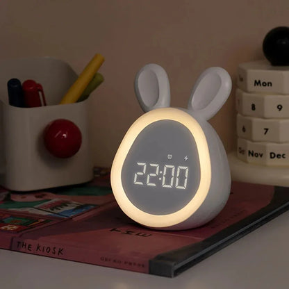 White rabbit-shaped night light with digital display on a desk