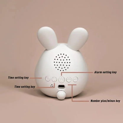 White rabbit-shaped alarm clock with labeled buttons on a beige background
