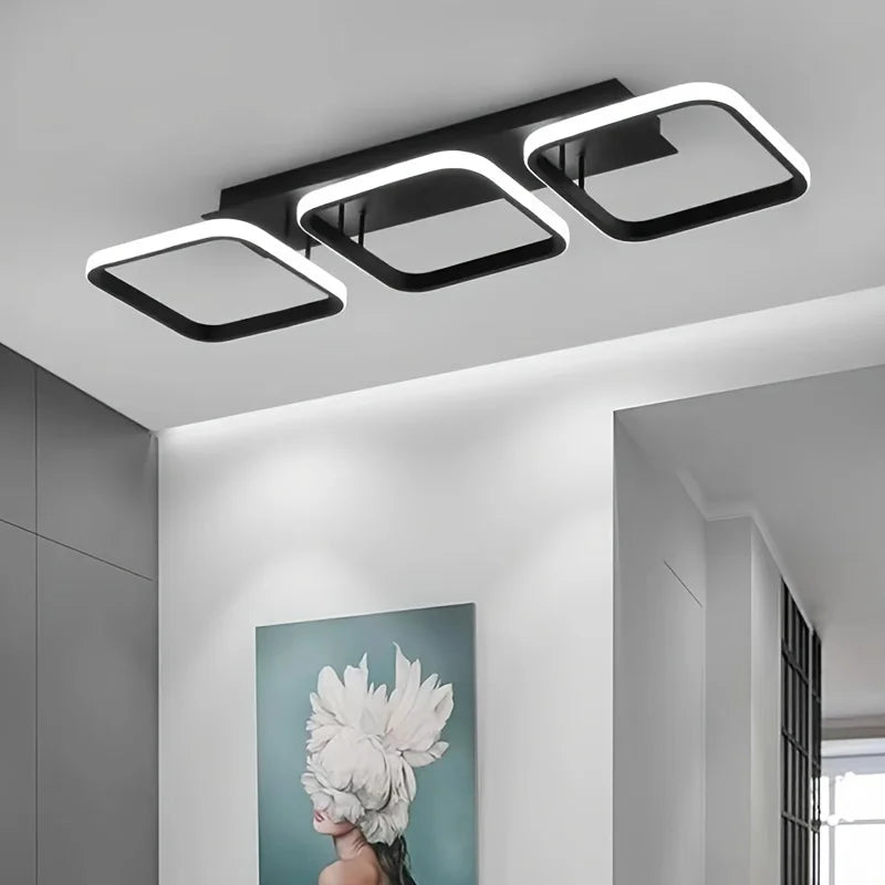 Modern ceiling light fixture in a room with a decorative wall art piece.