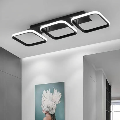 Modern ceiling light fixture in a room with a decorative wall art piece.