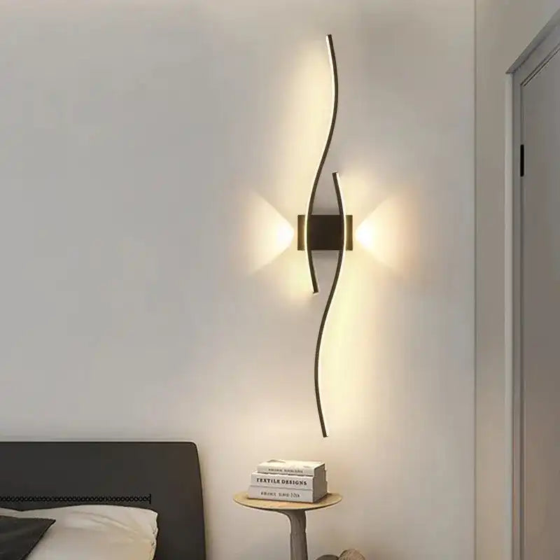 Modern wall lamp on a white wall with a bed and books in the foreground