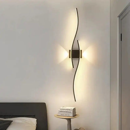 Modern wall lamp on a white wall with a bed and books in the foreground