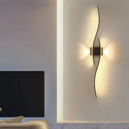 Modern wall lamp on a white wall with a television in the background