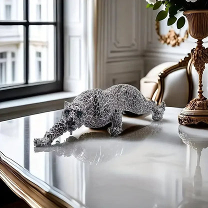 Decorative sculpture of a leopard on a reflective surface with a classical interior setting.