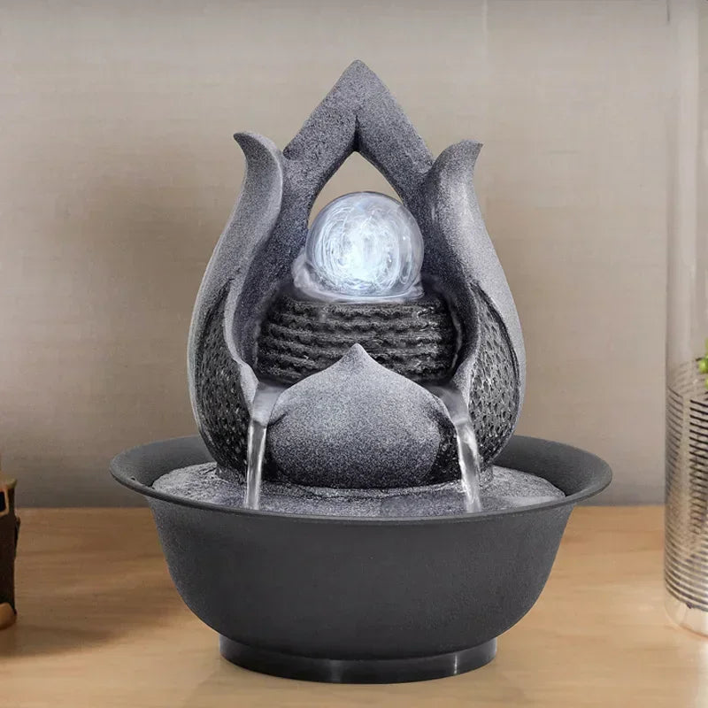 Decorative water fountain with stone-like design on a wooden surface.