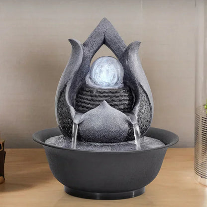 Decorative water fountain with stone-like design on a wooden surface.