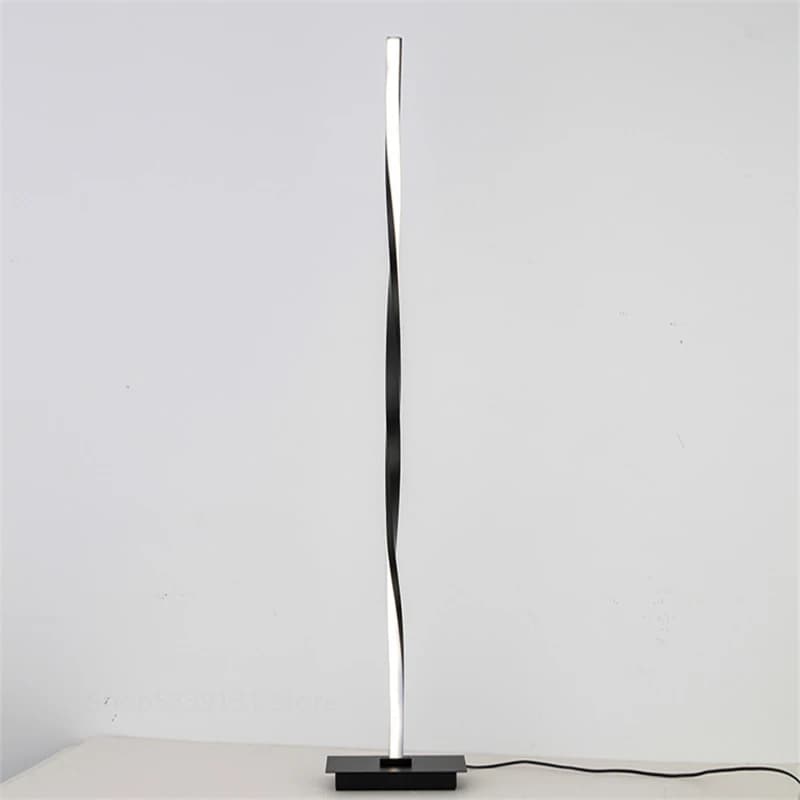 Modern black floor lamp on a white surface with a light gray background