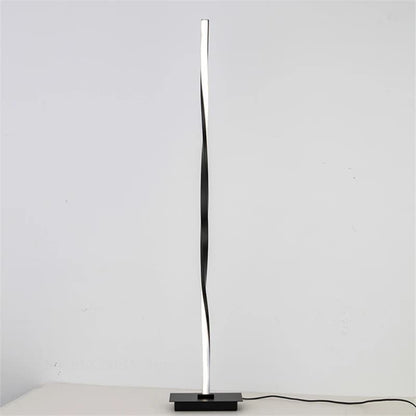Modern black floor lamp on a white surface with a light gray background