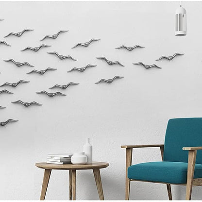 Modern interior with decorative metal birds on the wall, a teal chair, and a small table.