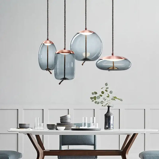 Modern pendant lights hanging above a dining table with a neutral background