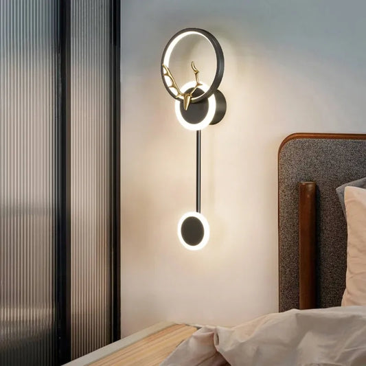 Modern wall lamp with deer head design on a bedroom wall.
