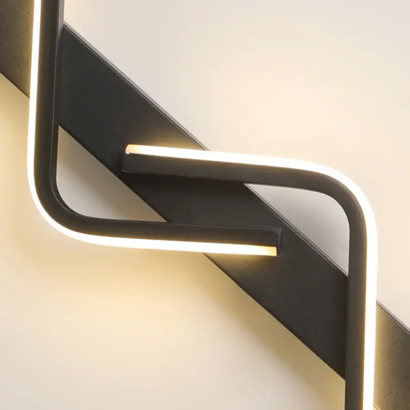 Modern wall light fixture with a black frame and a white LED strip on a neutral background