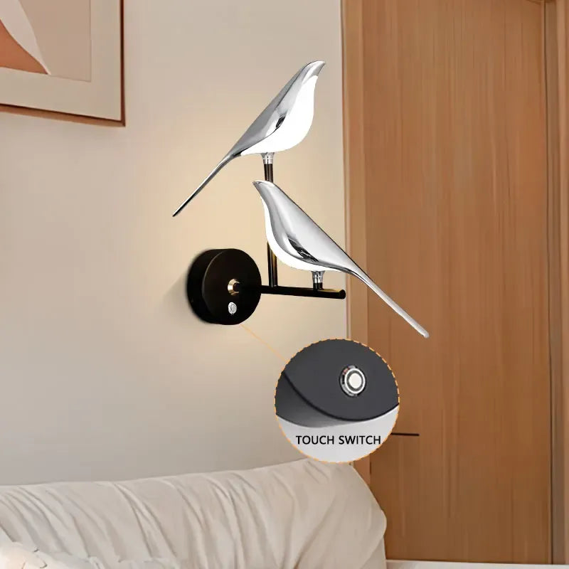 Modern wall sconce with bird design on a neutral wall.