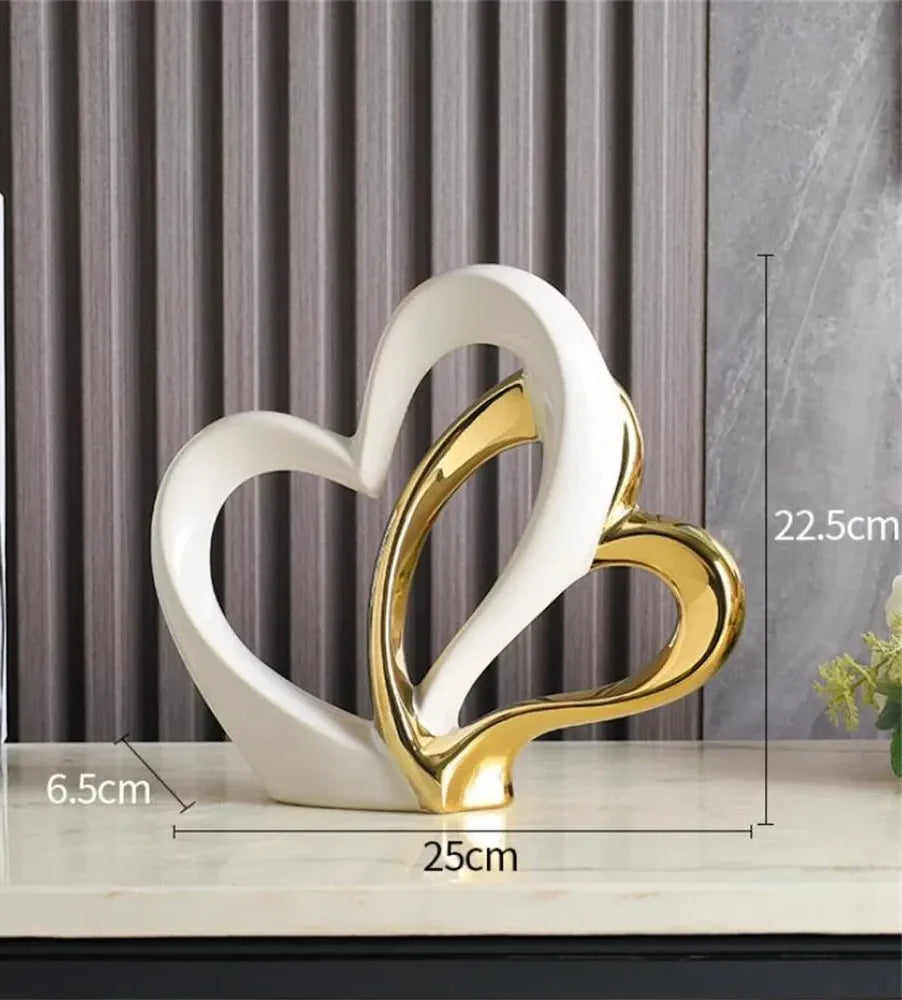 Decorative sculpture of two interlocking hearts, one white and one gold, on a surface with dimensions displayed.