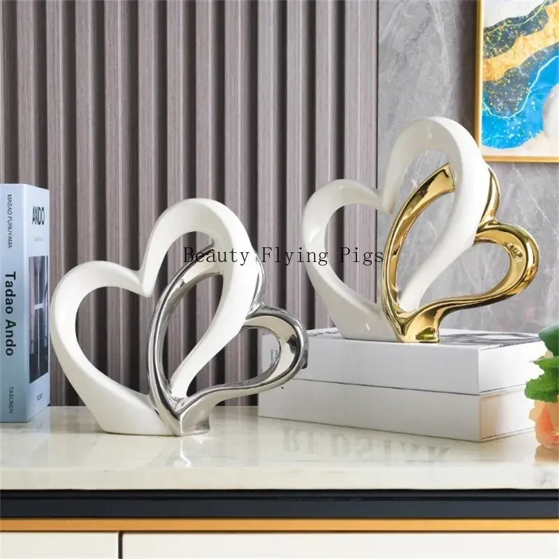 Decorative heart-shaped sculptures on a shelf with books and a painting in the background.