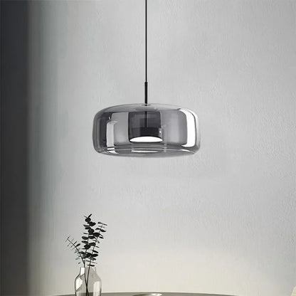 Modern pendant light with a glass shade on a neutral background