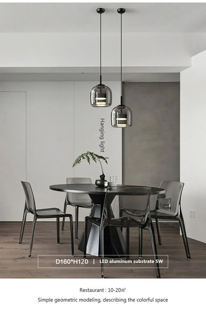 Modern dining area with a black table and chairs, featuring pendant lights.