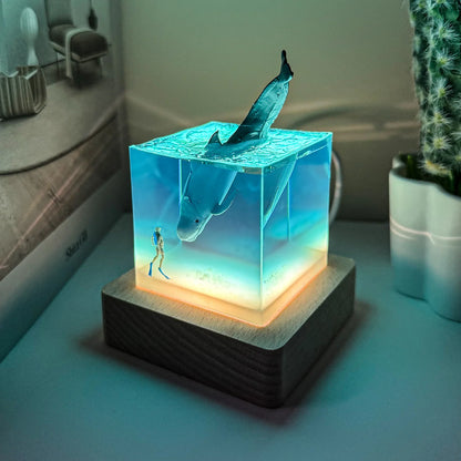 Decorative lamp with shark design on a wooden base, glowing in a room setting.