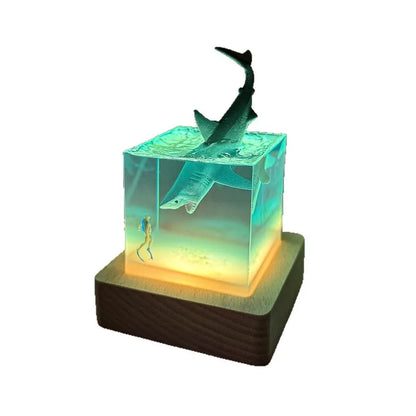 Shark figurine inside a transparent cube on a white background