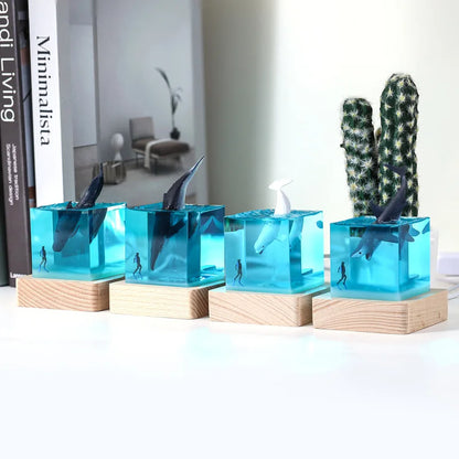 Set of four blue glass containers with wooden bases on a white surface.