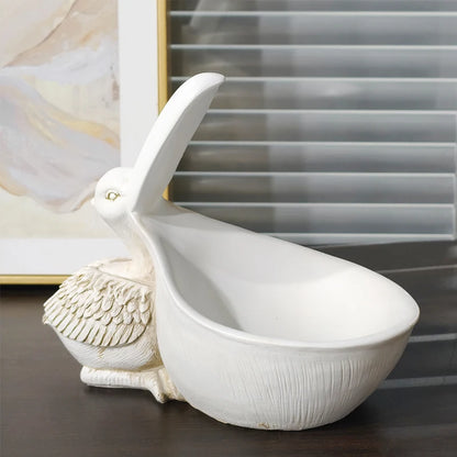 White ceramic bird-shaped bowl on a dark surface with a blurred background